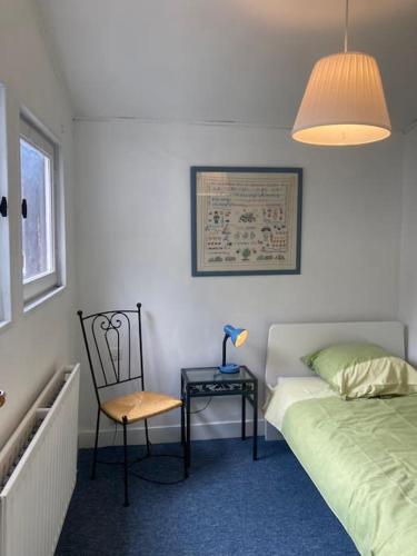 une chambre avec un lit, une chaise et une table dans l'établissement Appartement duplex de charme, à Rouen