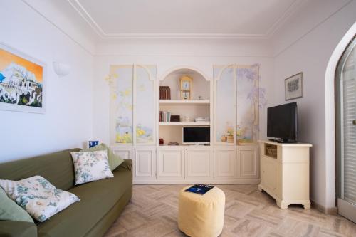 Una sala de estar con un sofá y un televisor. en Dimora Bruno e Rubina (centrale a Capri), en Capri
