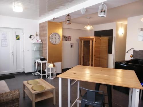 een kamer met een tafel en een klok aan de muur bij Ô Temps d'Amour Sauna&Jacuzzi in Malissard