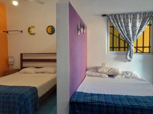 1 dormitorio con 2 camas y ventana en Amanecer, en Sayulita