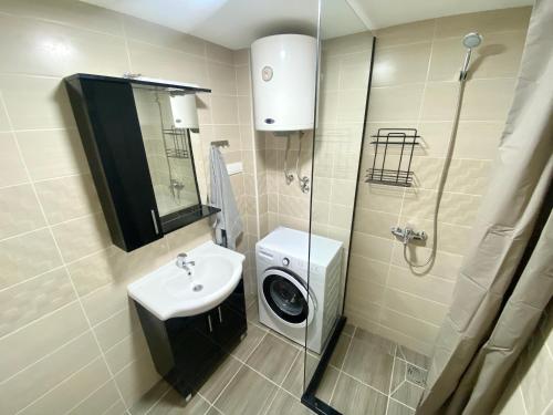 uma casa de banho com um lavatório e uma máquina de lavar roupa em SutoMarina Apartments em Sutomore