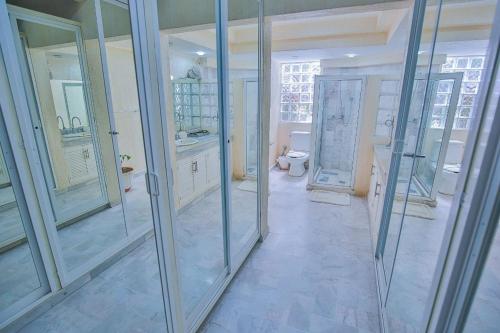 a bathroom with glass doors and a toilet in it at Casa con alberca con vistas a la bahia in Acapulco