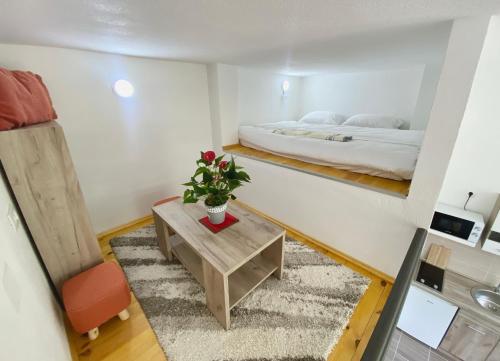 um pequeno quarto com uma cama e uma mesa em SutoMarina Apartments em Sutomore