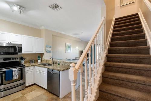 a kitchen with a staircase with a sink and a stove at Beach House Getaway in Duck Key