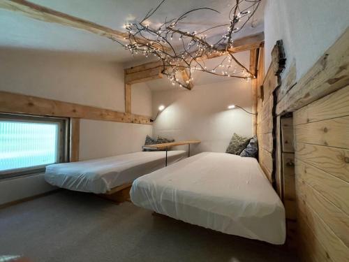 1 dormitorio con 2 camas y lámpara de araña en Backyard Mountain Hostel, en Mayrhofen