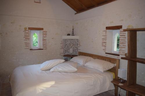 Lapis Domus في Francueil: غرفة نوم بسرير ذو شراشف ووسائد بيضاء