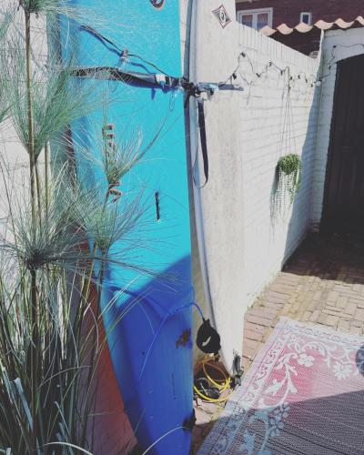 a blue surfboard is leaning against a wall at Zandvoortferienwohnungen in Zandvoort