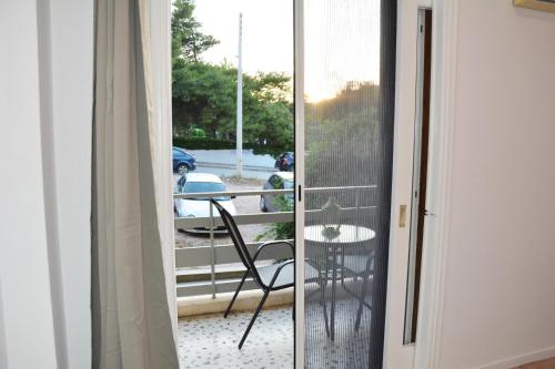 a room with a balcony with a chair and a table at Comfy house in varkiza in Varkiza