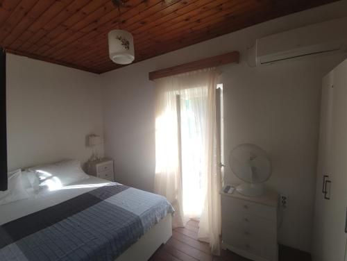 a bedroom with a bed and a window at Reset cottage in Velianitátika