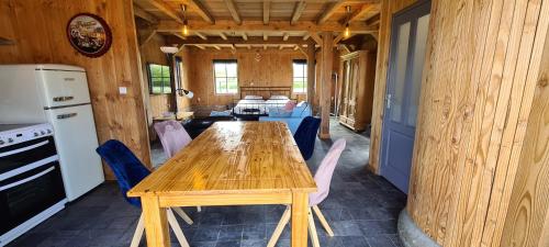 a kitchen and dining room with a wooden table and chairs at Den Hooimijt in Kats