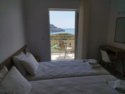 a hotel room with two beds and a view of the ocean at Sun & Sea Apartments Plakias II in Plakias