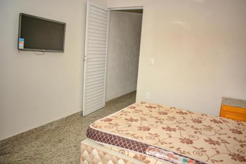 卡波布里奥AP perto da Praia do Forte Cabo Frio的一间卧室，里面有一张床和一台平板电视