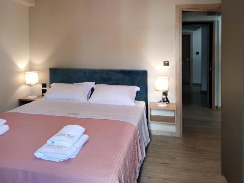 a bedroom with a bed with two towels on it at Volos Terra Deluxe Residences in Volos