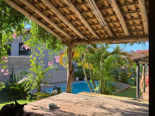 a cat sitting on a table in front of a pool at Solar da Suzi in Praia do Rosa