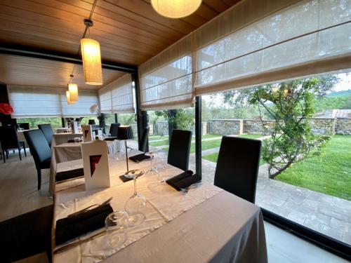 une salle à manger avec une table et une grande fenêtre dans l'établissement Fattoria Pianetti, à Manciano