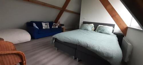 a bedroom with a bed and a blue chair at Superior Familiekamer met eigen badkamer OF een Privékamer met eigen inloopdouche in Anna Paulowna