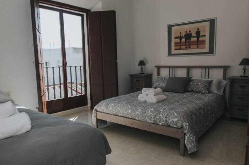 een slaapkamer met een bed met een knuffeldier erop bij Gran casa con piscina centro de sevilla Vistas in Sevilla