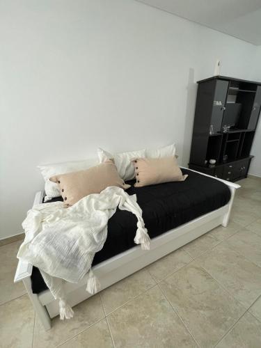 una cama con almohadas en una habitación en Gerbera Colorada HAEDO en Mariano J. Haedo