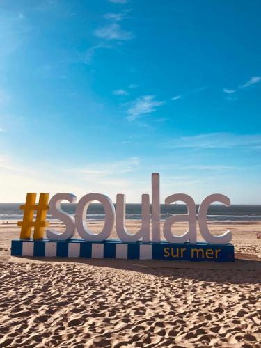 a sign on a beach with the word sutras at Hôtel Michelet Plage in Soulac-sur-Mer