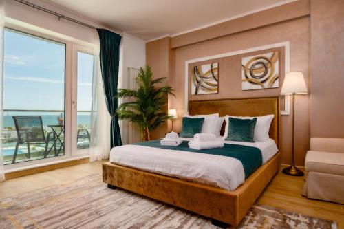 - une chambre avec un grand lit et une grande fenêtre dans l'établissement RoseBay std - Infinity Pool & Spa Resort, à Mamaia Nord – Năvodari