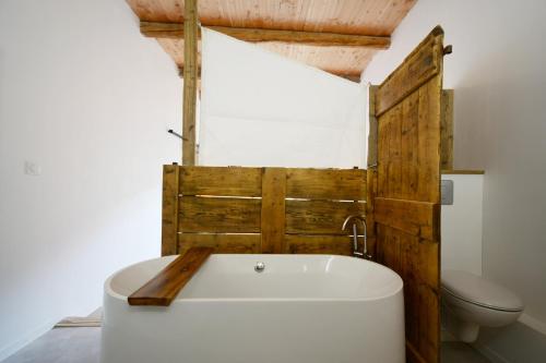 La salle de bains est pourvue d'une baignoire blanche et de toilettes. dans l'établissement La Mélézière-Ecrin Appartement 4 étoiles 120m2 6 personnes plein sud, aux Orres