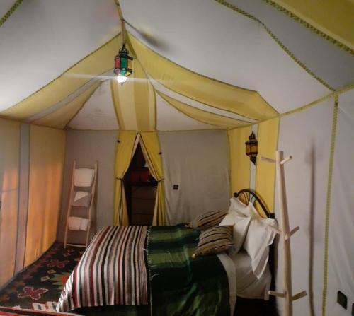 a bedroom with a bed in a tent at Desert Paradise Luxury Camp in Merzouga