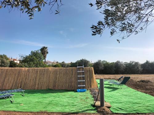 a playground with a ladder and a green lawn at Refúgio na Aldeia in Ourique