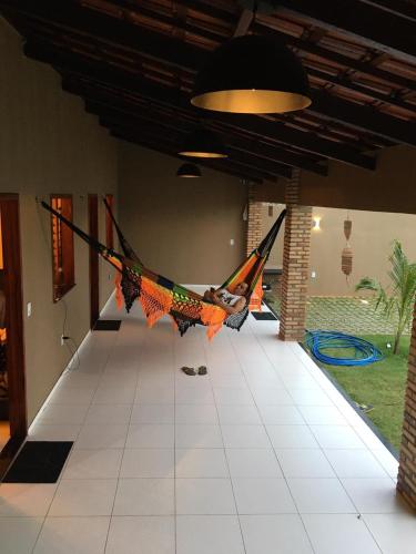 a person laying in a hammock in a room at Casa de praia - Trairí CE in Trairi