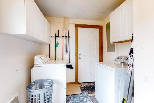Our Happy Place في روكواي بيتش: غرفة صغيرة لغسيل الملابس مع غسالة ومجفف