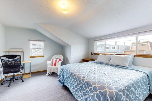 a bedroom with a bed and a chair and a window at Our Happy Place in Rockaway Beach