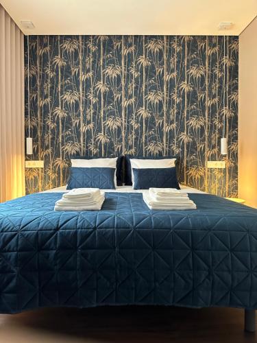 a bedroom with a blue bed with a wallpaper at House Real Companhia in Vila Nova de Gaia