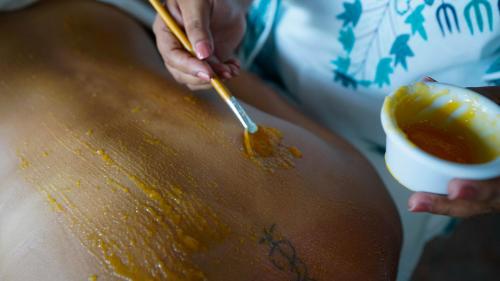 a person is mixing honey on a table with a spoon at Hotel Rio Lagartos in Río Lagartos
