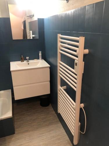 une salle de bain avec un lavabo blanc et un miroir dans l'établissement Arcachon charmant studio sur le port aperçu mer., à Arcachon