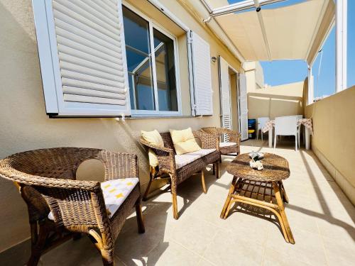 a patio with wicker chairs and a table at Atmosfere di mare in Marina di Ragusa