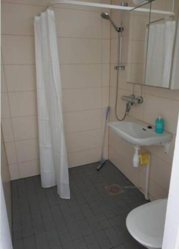 a bathroom with a shower curtain and a sink at Studio Pearl in Taalintehdas