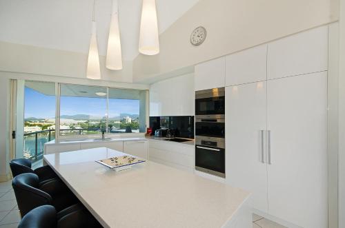 a white kitchen with a large white counter top at Mariners North Holiday Apartments in Townsville