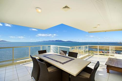 
a dining room table with a view of the ocean at Mariners North Holiday Apartments in Townsville

