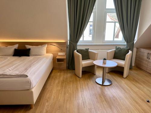 um quarto de hotel com uma cama, uma mesa e cadeiras em Hotel Bronnbacher Hof em Wertheim