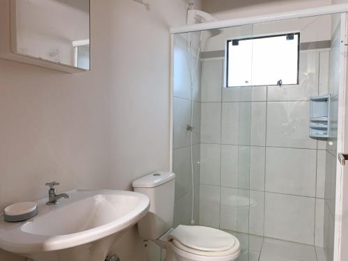 een badkamer met een toilet, een wastafel en een douche bij Residencial COLIBRI in Garopaba