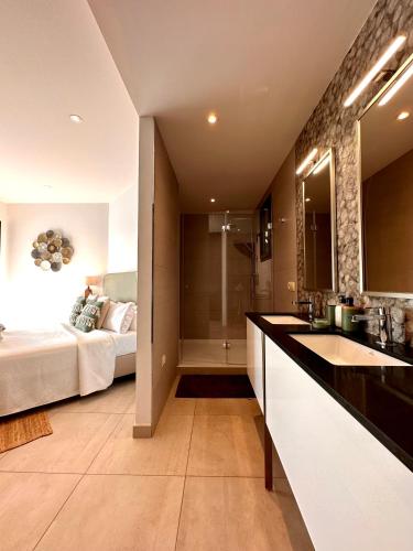 a bathroom with a sink and a bedroom with a bed at Villa Cas Hespero in San Antonio