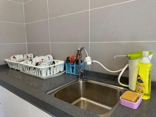 a kitchen sink with utensils in a drying rack next to it at [OFFICIAL] Desaru Villa Resort @ Arcadia in Desaru