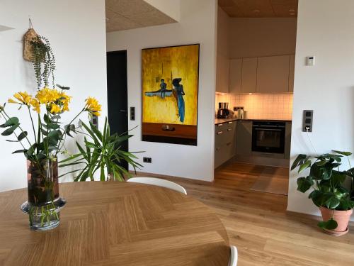 a kitchen and dining room with a wooden table with flowers at Atlantic Jewel in Tórshavn