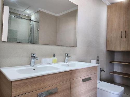 a bathroom with a sink and a toilet at Magnifique Penthouse 140m2 de terrasse vue mer in Dar Bouazza