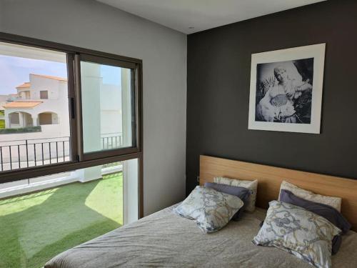 una camera con un letto e una grande finestra di Magnifique Penthouse 140m2 de terrasse vue mer a Dar Bouazza