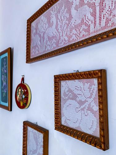 a wall with two framed pictures and a clock at Oda`s Room in Sarandë