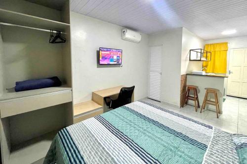 1 dormitorio con cama, escritorio y cocina en Apartamento Studio Centro en Macapá