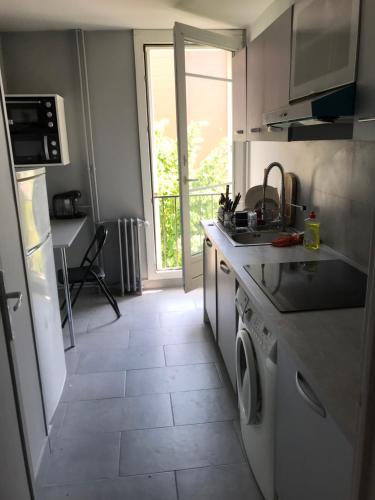 a kitchen with a sink and a stove top oven at Nice Stay - La Noue in Villeneuve-la-Garenne