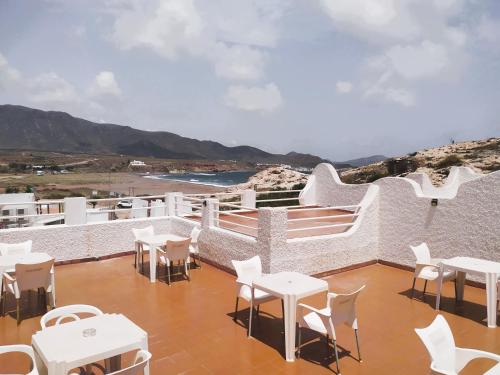 un patio con mesas, mesas blancas y sillas en HOSTAL CASA EMILIO, en Almería