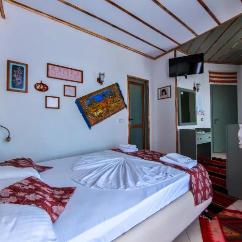 a bedroom with two beds and a flat screen tv at Oda`s Room in Sarandë