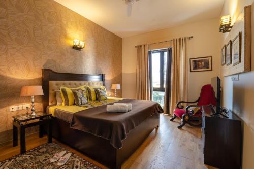 a bedroom with a bed and a chair in a room at Stylish 2BHK apartment with highspeed WiFi & kitchen near Golf Course Road, GGN in Gurgaon